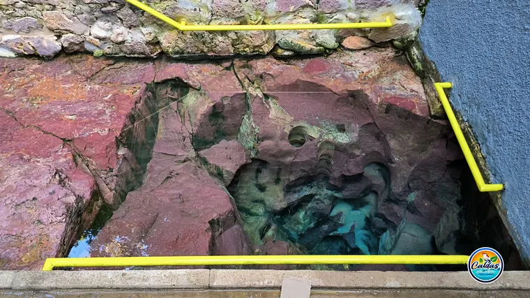 Uma das bicas históricas esculpida na rocha, com corrimão de apoio