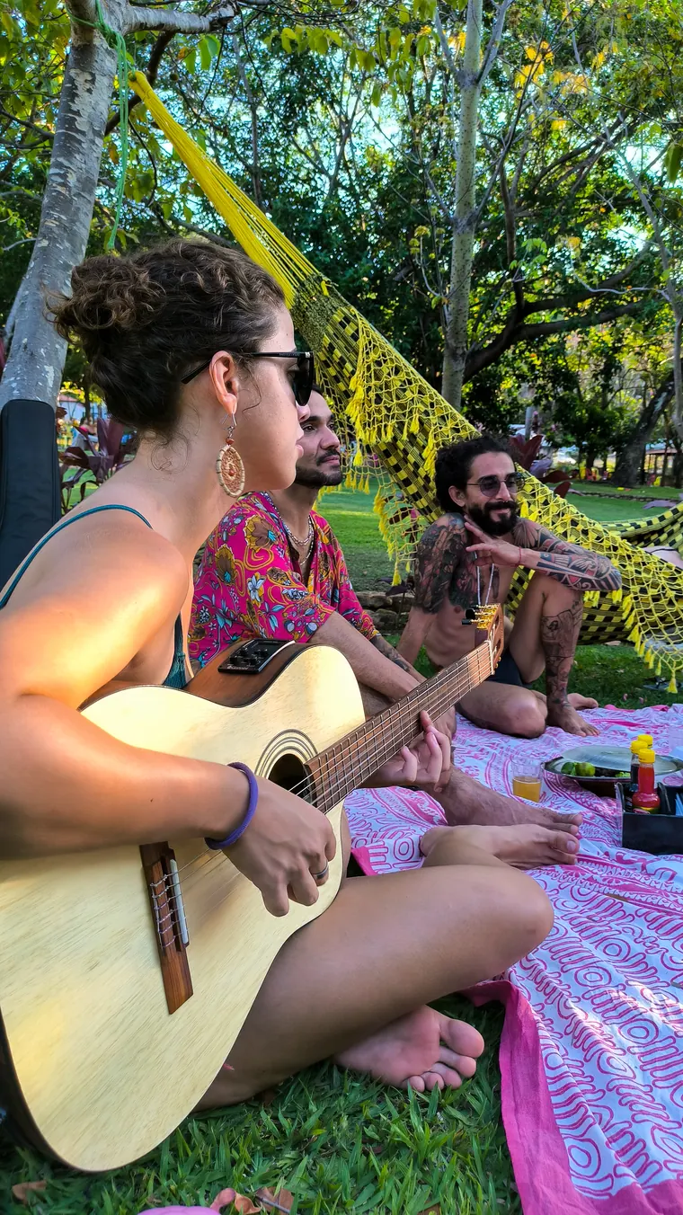 Tarde de música e piquenique no gramado, à sombra das árvores