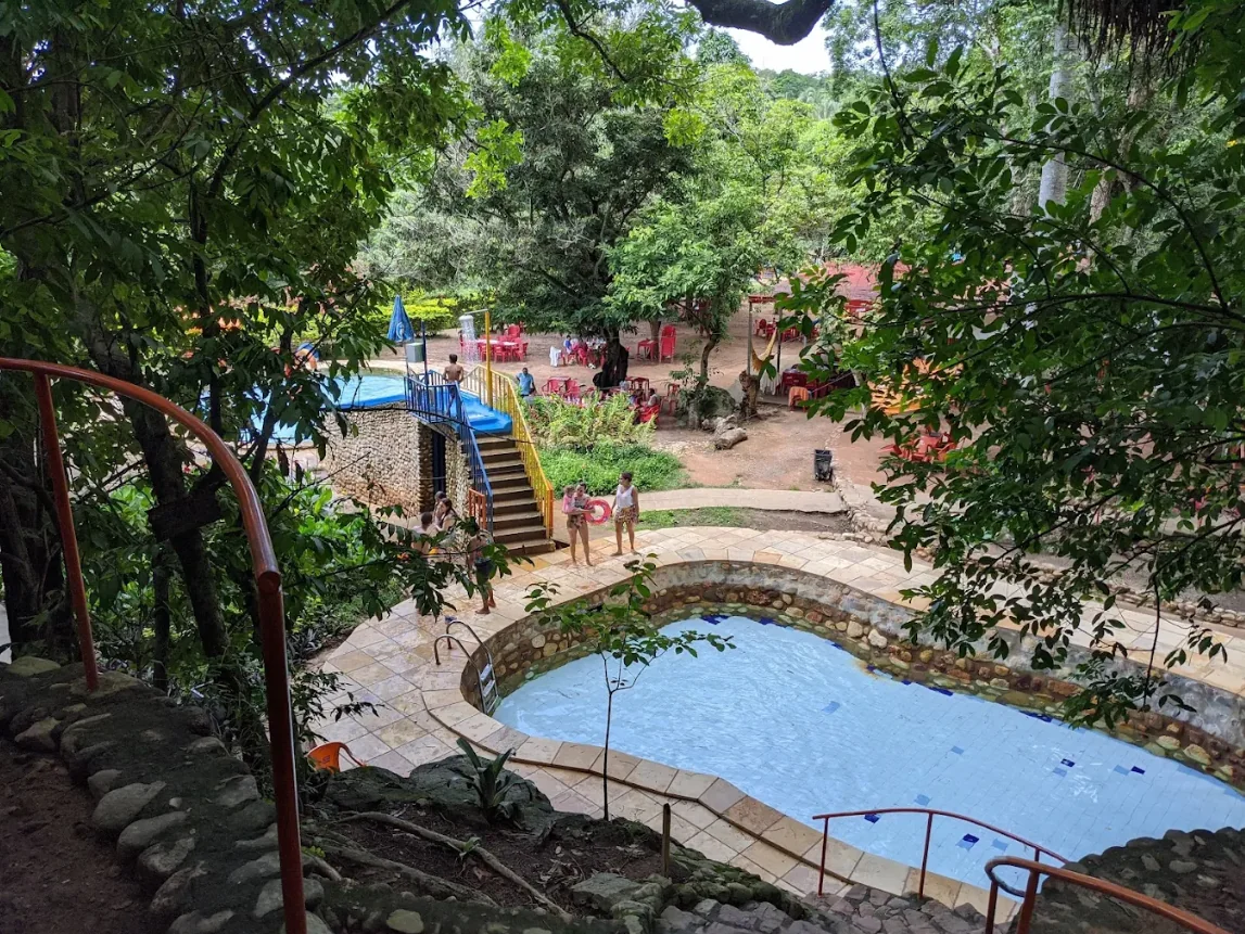 Piscina de água corrente vista do alto entre as árvores do Caldas