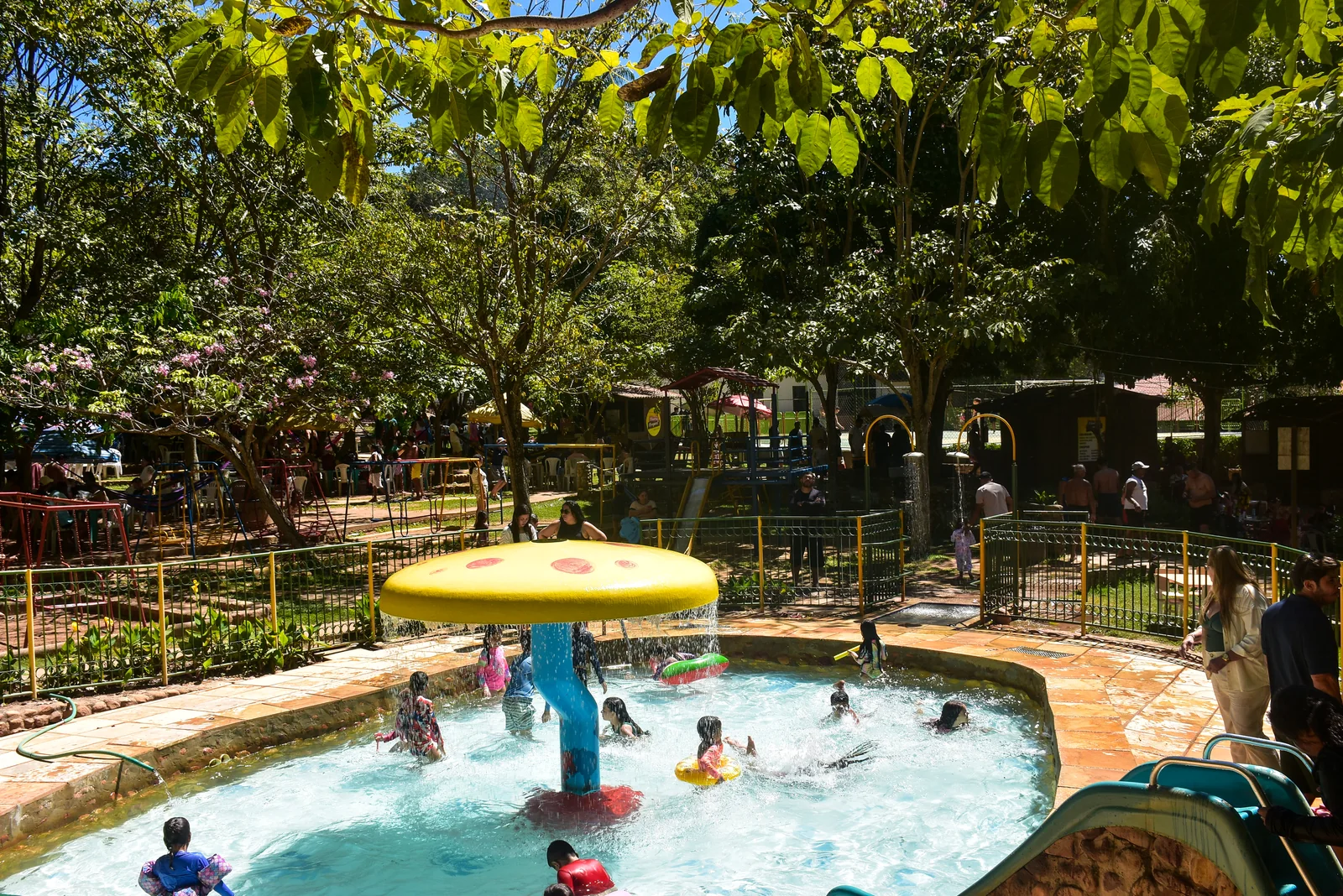 Piscina infantil com chuveiro de cogumelo e famílias no Balneário do Caldas